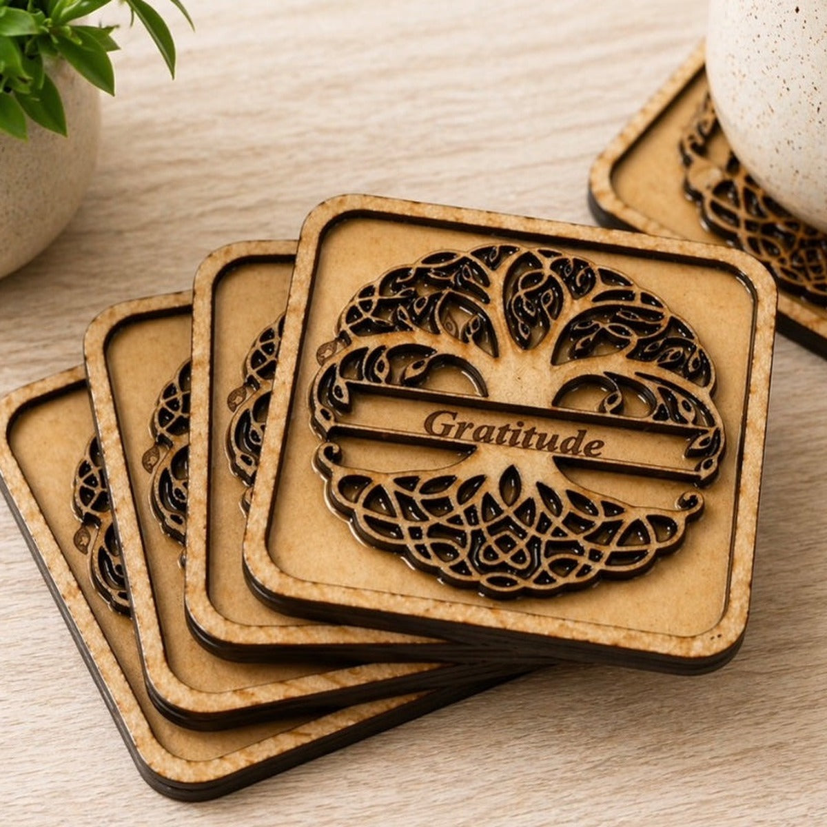 Tree of Life coaster set fanned on wood table